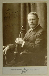 Hugo Heermann (1844-1935), der Initiator der deutschen Erstaufführung des Sextetts. Undatierte Portraitphotographie aus dem Studio von Arthur Marx, mit Notenzitat (Incipit der Solostimme von Beethovens Violinkonzert) und verblaßter Widmung an den amerikanischen Geiger Henry C. Heyman (1855-1924).